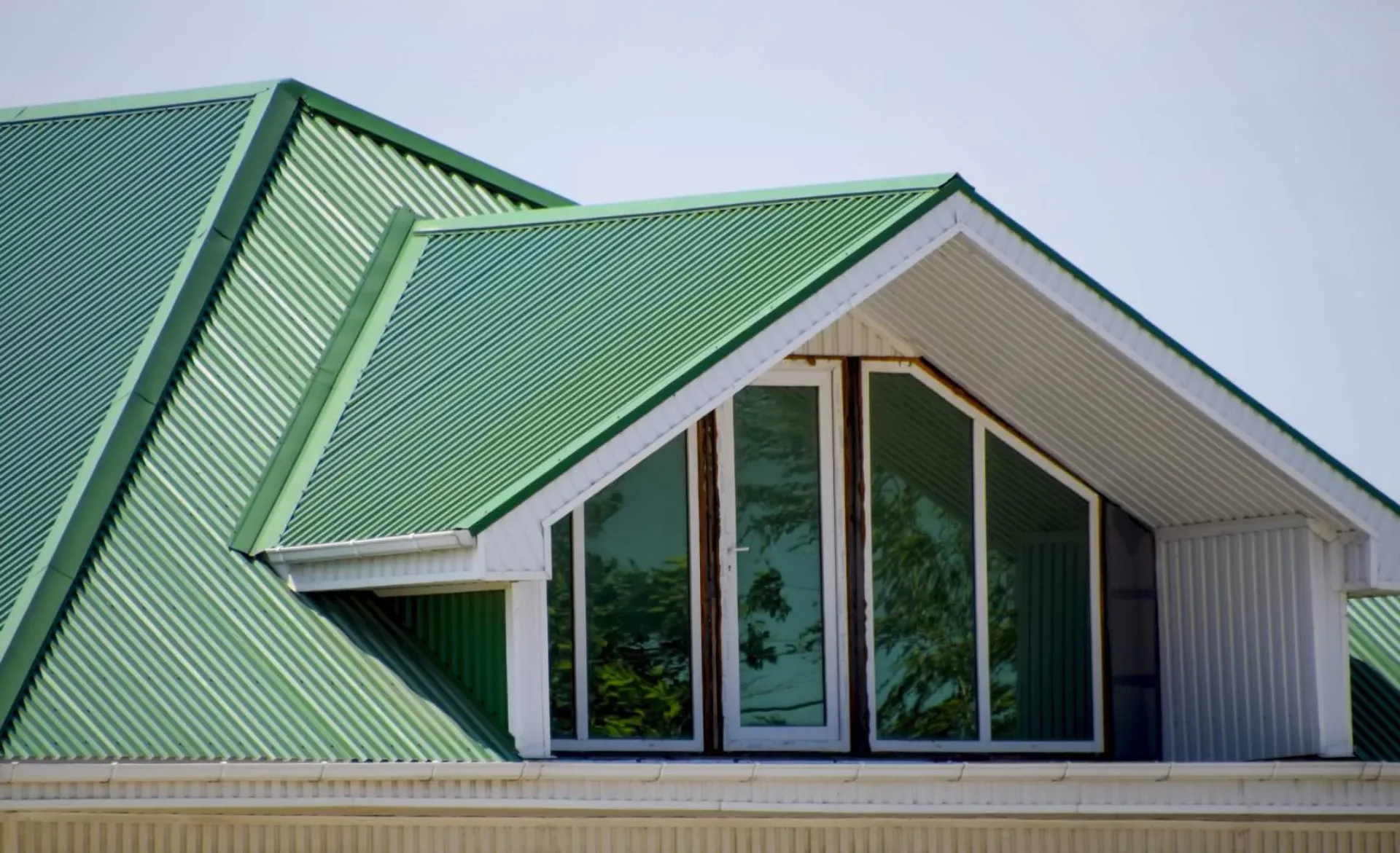 The house with plastic windows and a green roof of corrugated sh