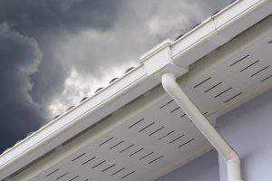 white plastic rain gutter and dark sky. concept : preparing maintenance rain gutter before rainy season.