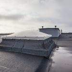 Plastic dome on a flat roof on a large building in the heart of the city
