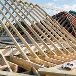 Renovation projects. Building of extension of the existing house, unfinished wooden roof structure, selective focus