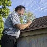 Insurance adjuster figuring hail damge done to insureds roof.